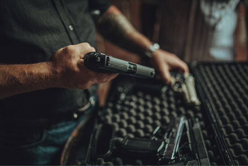 Homepage 33 man picking up handgun from case