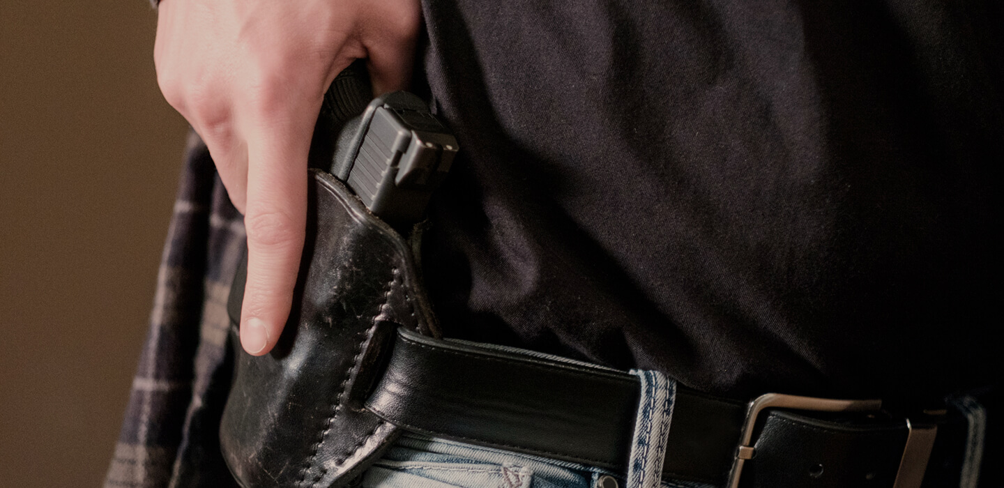 man with hand on holster with gun