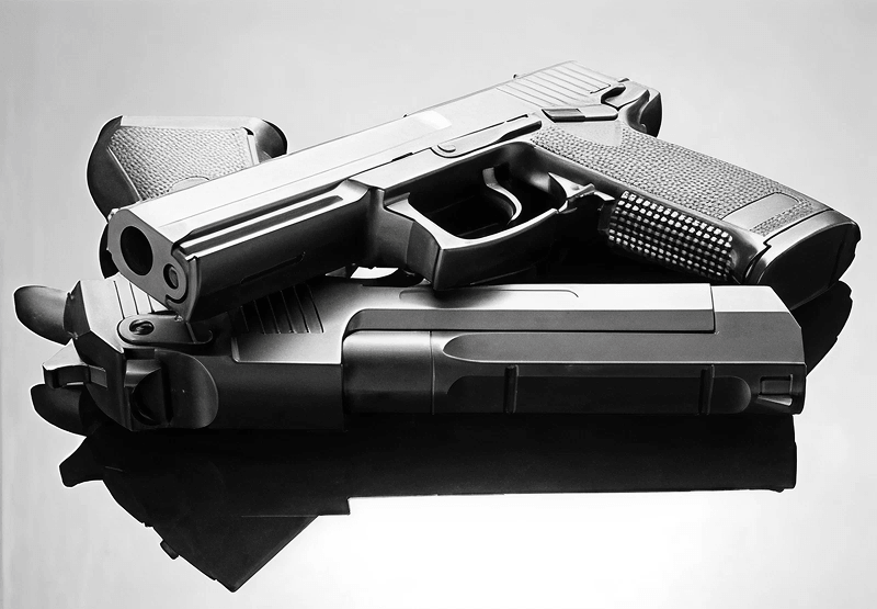 two hand guns laying on top of one another